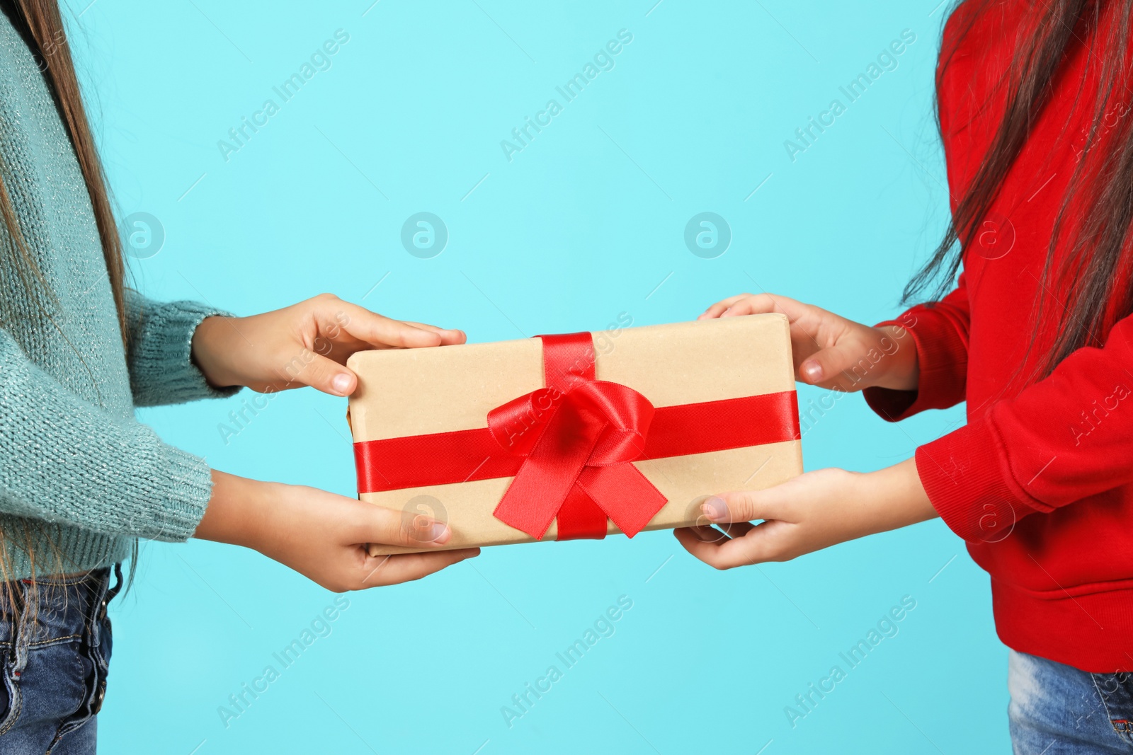 Photo of Cute little children with Christmas gift on color background