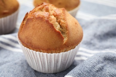 Tasty muffin in paper cup on table, closeup