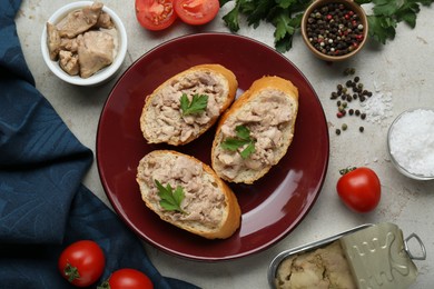 Photo of Tasty sandwiches with cod liver and different products on light grey table, flat lay