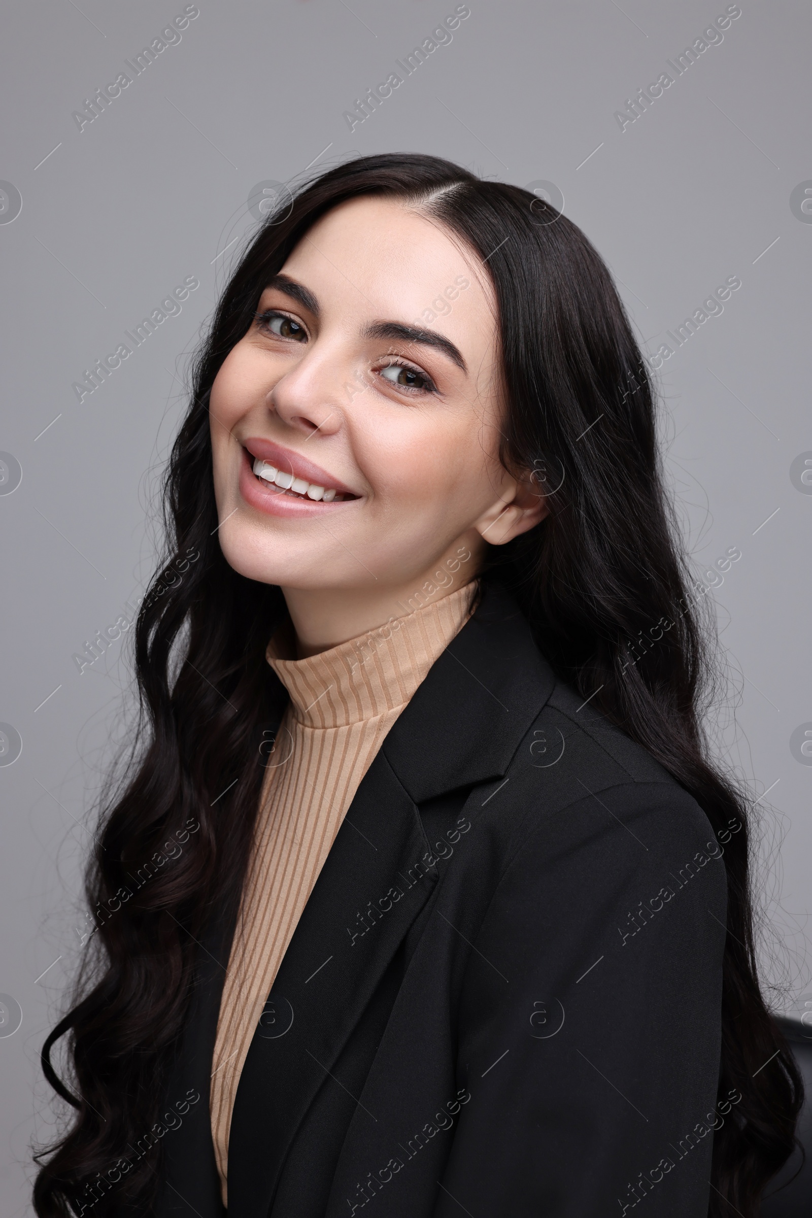 Photo of Beautiful woman in black jacket on gray background