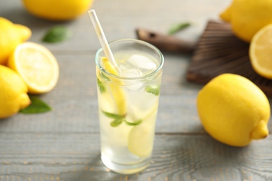 Photo of Cool freshly made lemonade and fruits on grey wooden table, closeup