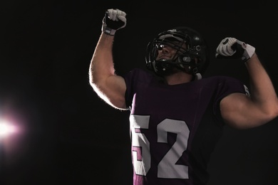 American football player wearing uniform on dark background