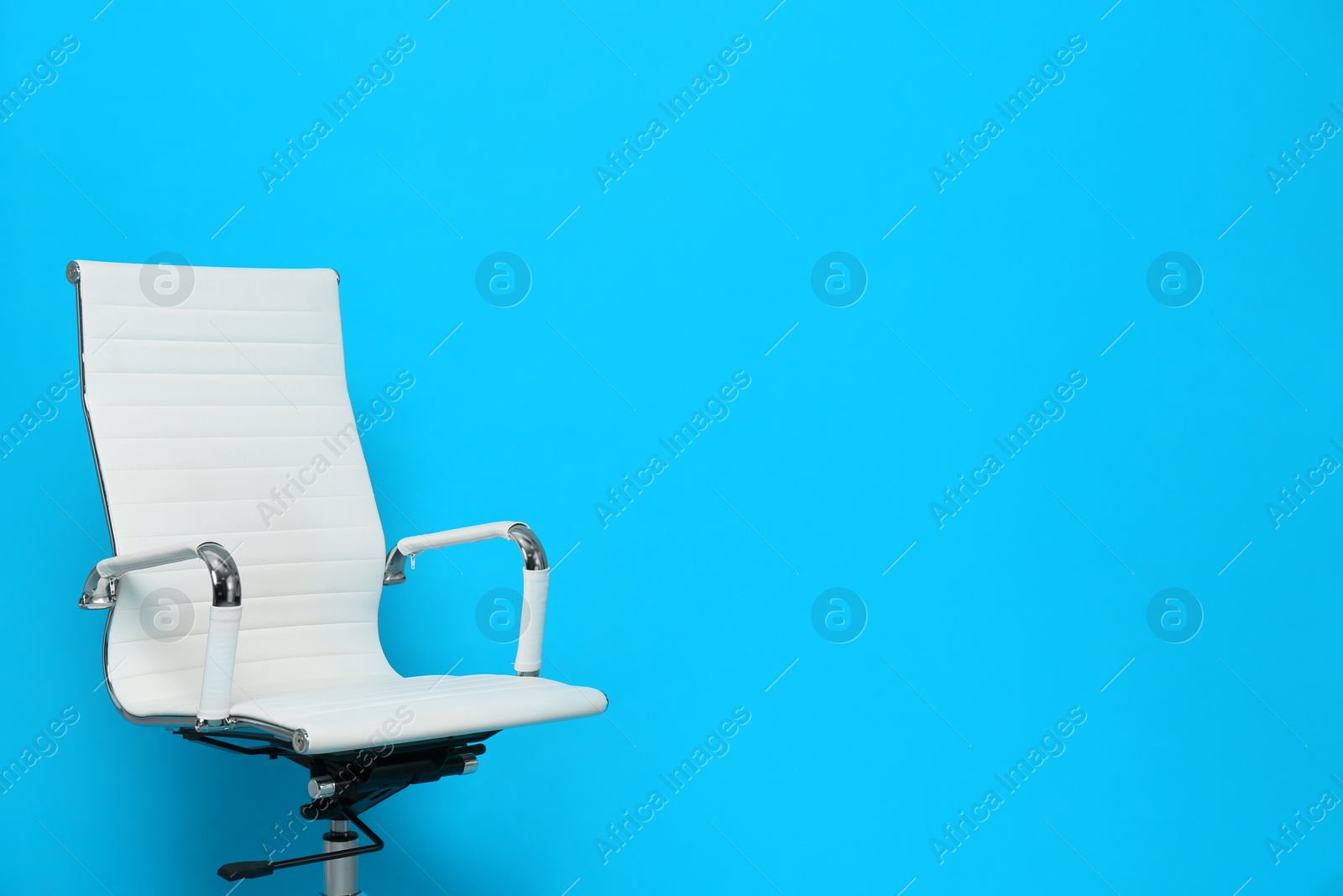 Photo of Comfortable office chair on light blue background, space for text