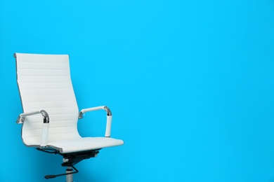 Comfortable office chair on light blue background, space for text