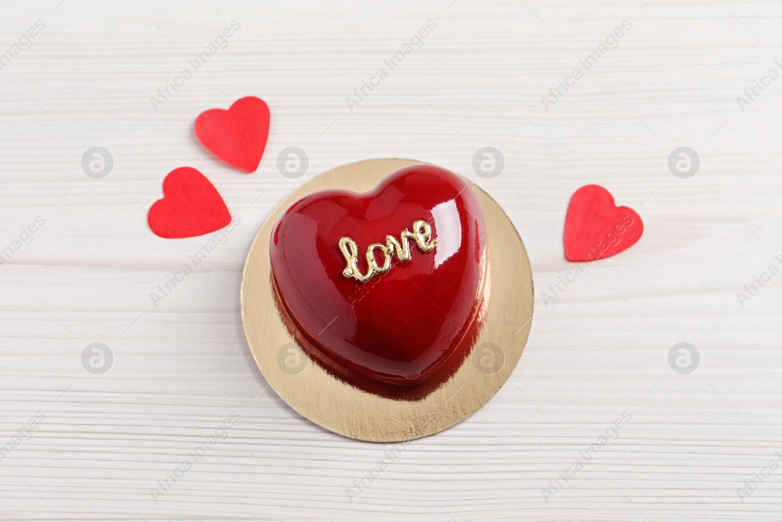 Photo of St. Valentine's Day. Delicious heart shaped cake and confetti on white wooden table, top view