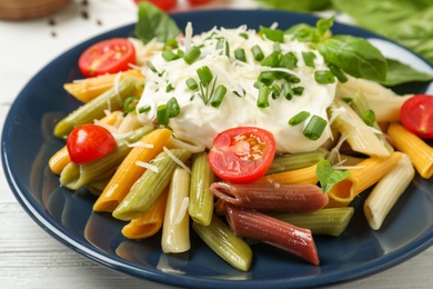 Delicious pasta with sour cream on white wooden table, closeup