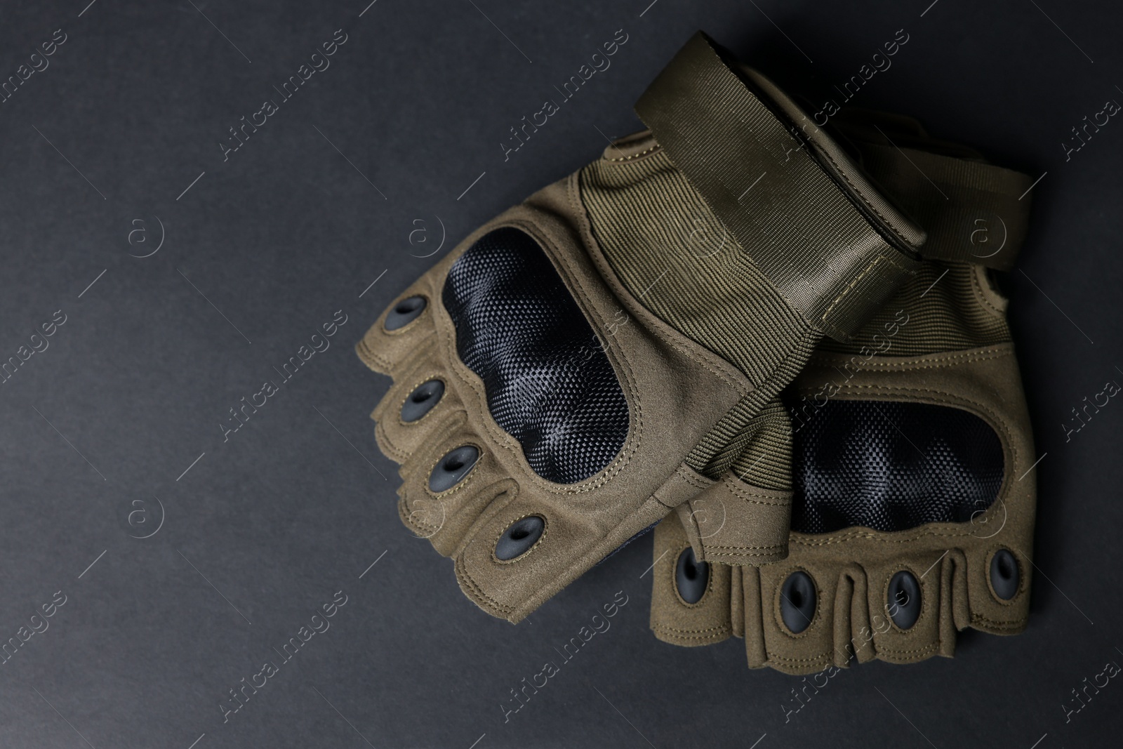 Photo of Tactical gloves on black background, flat lay with space for text. Military training equipment