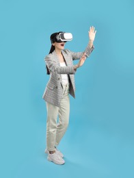 Photo of Woman using virtual reality headset on light blue background