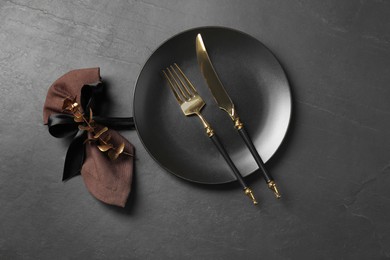 Photo of Stylish setting with elegant cutlery on grey textured table, flat lay