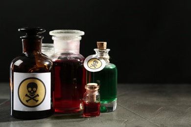 Photo of Bottles with poison on grey table. Space for text