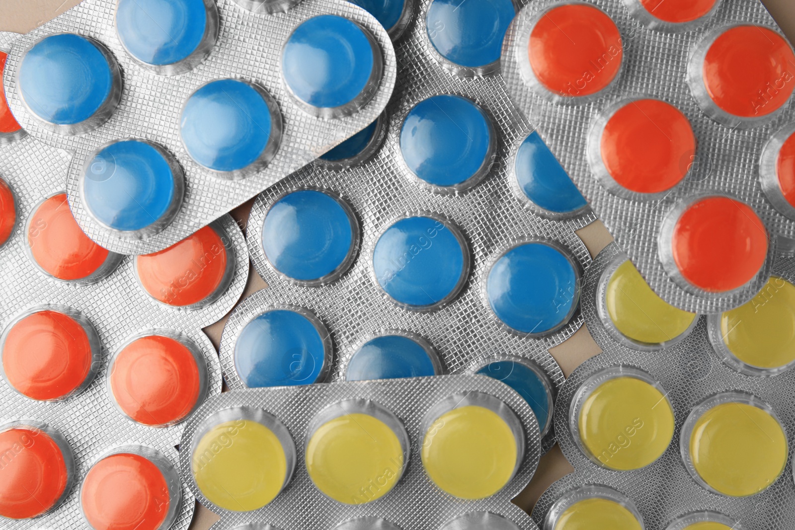 Photo of Blisters with colorful cough drops as background, top view