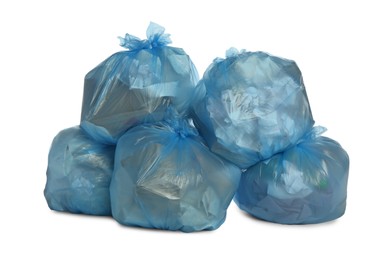 Blue trash bags filled with garbage on white background