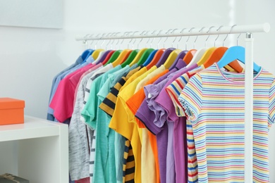 Photo of Different child's clothes hanging on rack in room