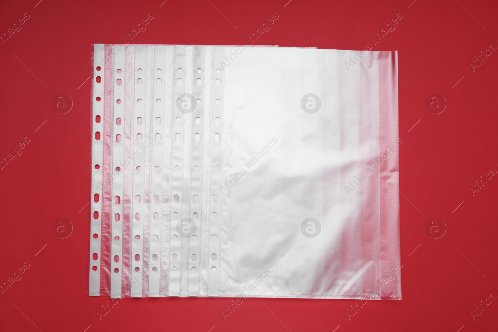 Photo of Punched pockets on red background, flat lay