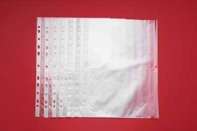 Photo of Punched pockets on red background, flat lay