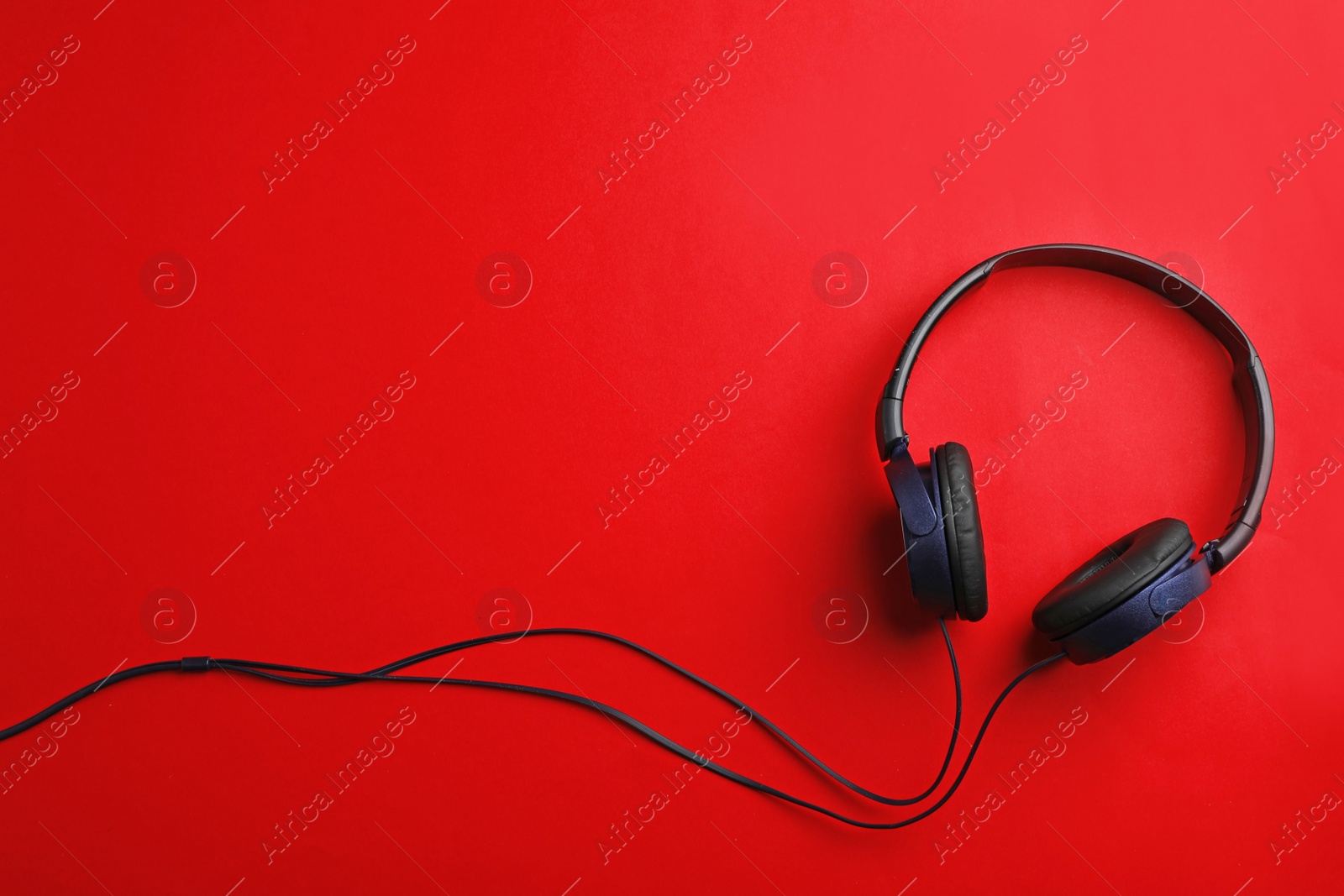 Photo of Stylish headphones on color background, top view. Space for text