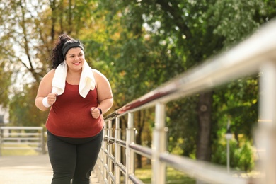 Photo of Beautiful overweight woman running outdoors. Fitness lifestyle