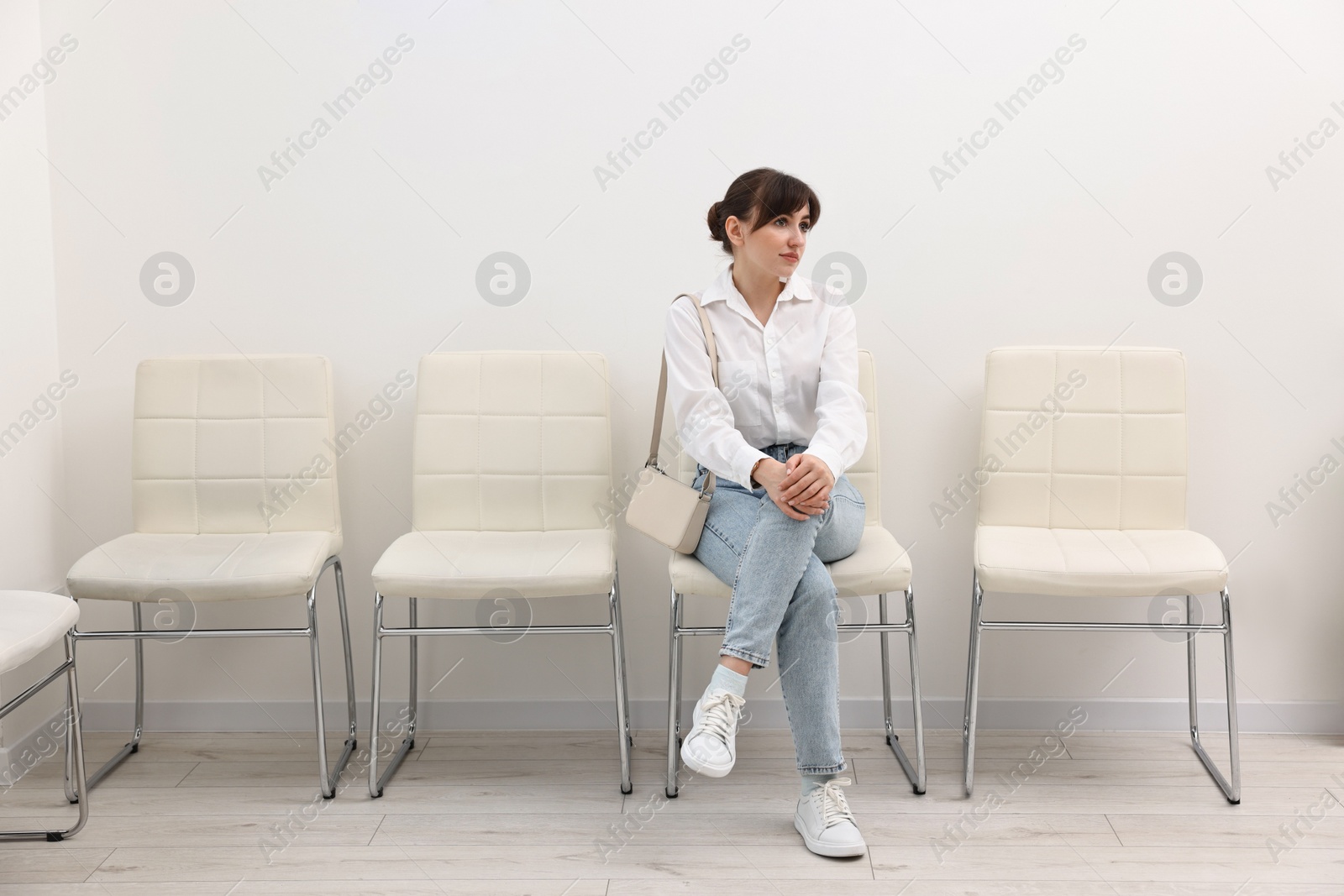 Photo of Woman sitting on chair and waiting for job interview indoors