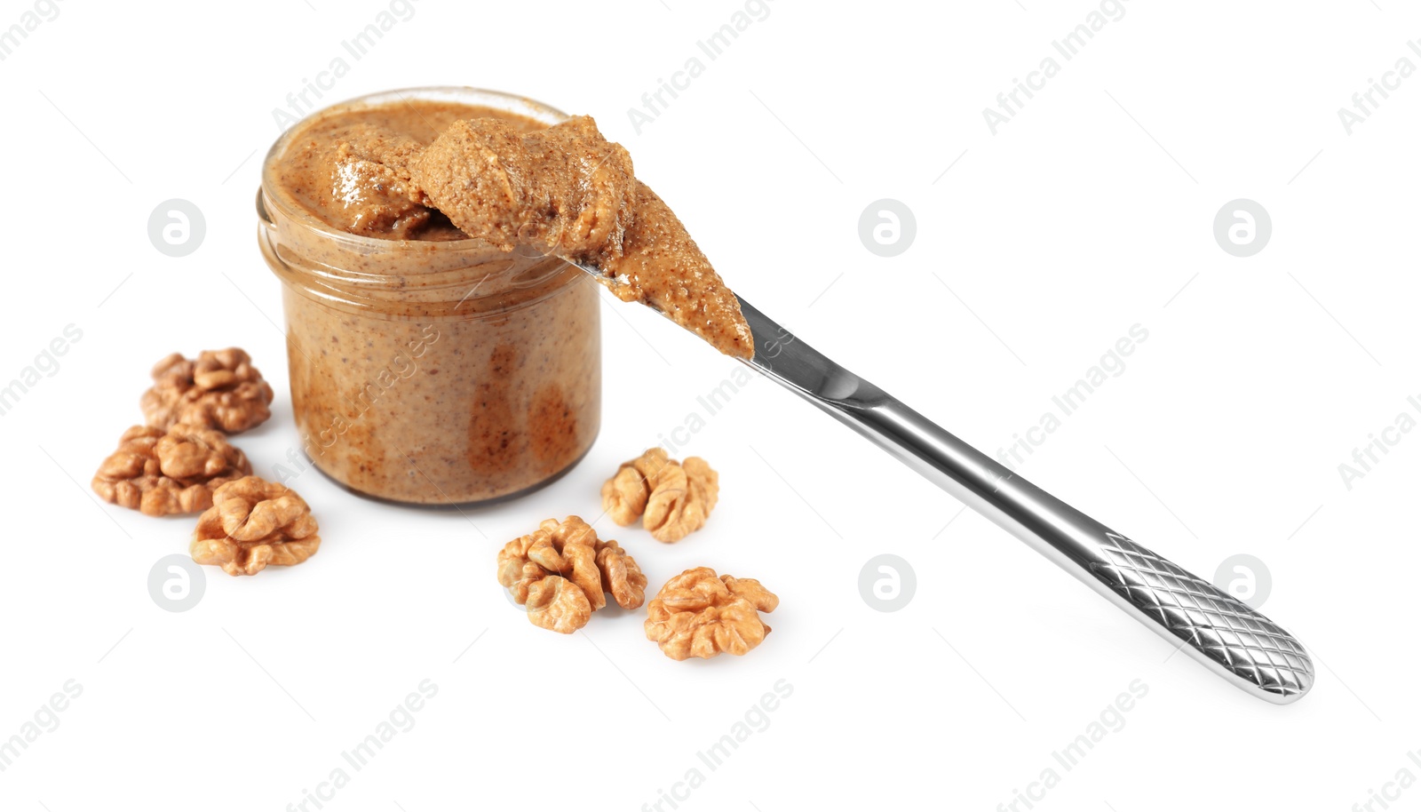 Photo of Delicious nut butter in jar, knife and walnuts isolated on white