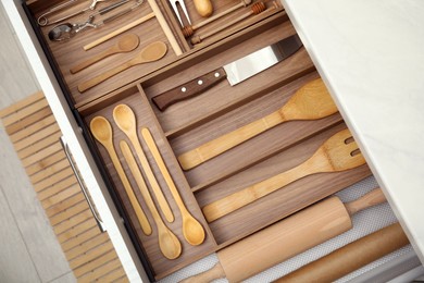 Open drawer of kitchen cabinet with different utensils, top view