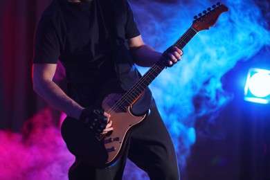 Man playing electric guitar on stage, closeup. Rock music