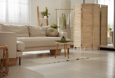 Stylish living room interior with comfortable grey sofa and plants
