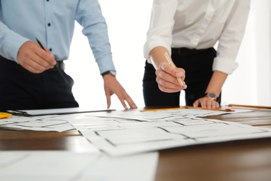 People working with construction drawings at table, closeup