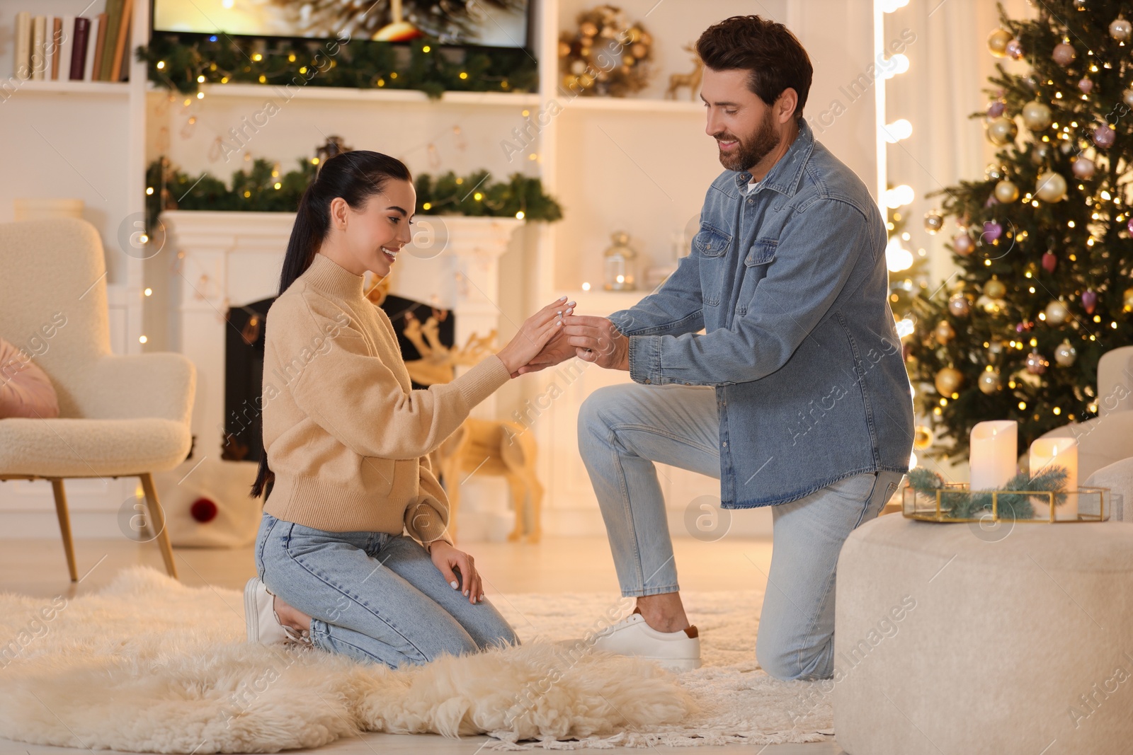 Photo of Man with engagement ring making proposal to his girlfriend at home on Christmas