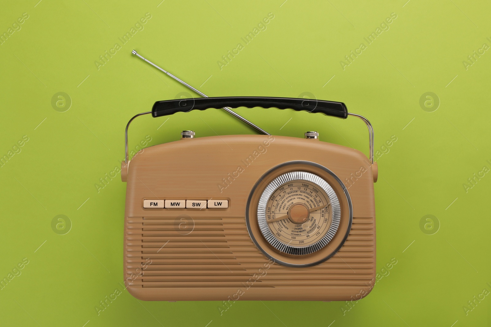 Photo of Retro radio receiver on light green background, top view