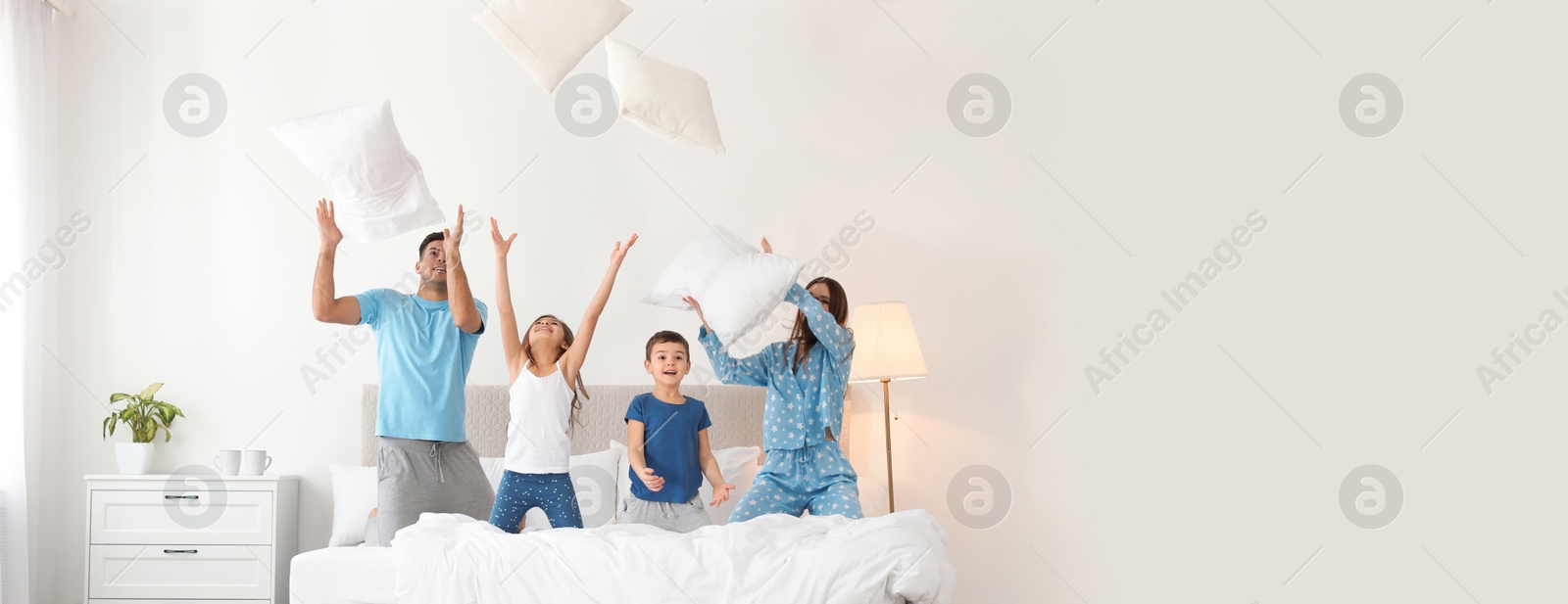 Image of Happy family playing with pillows in bedroom, space for text. Banner design