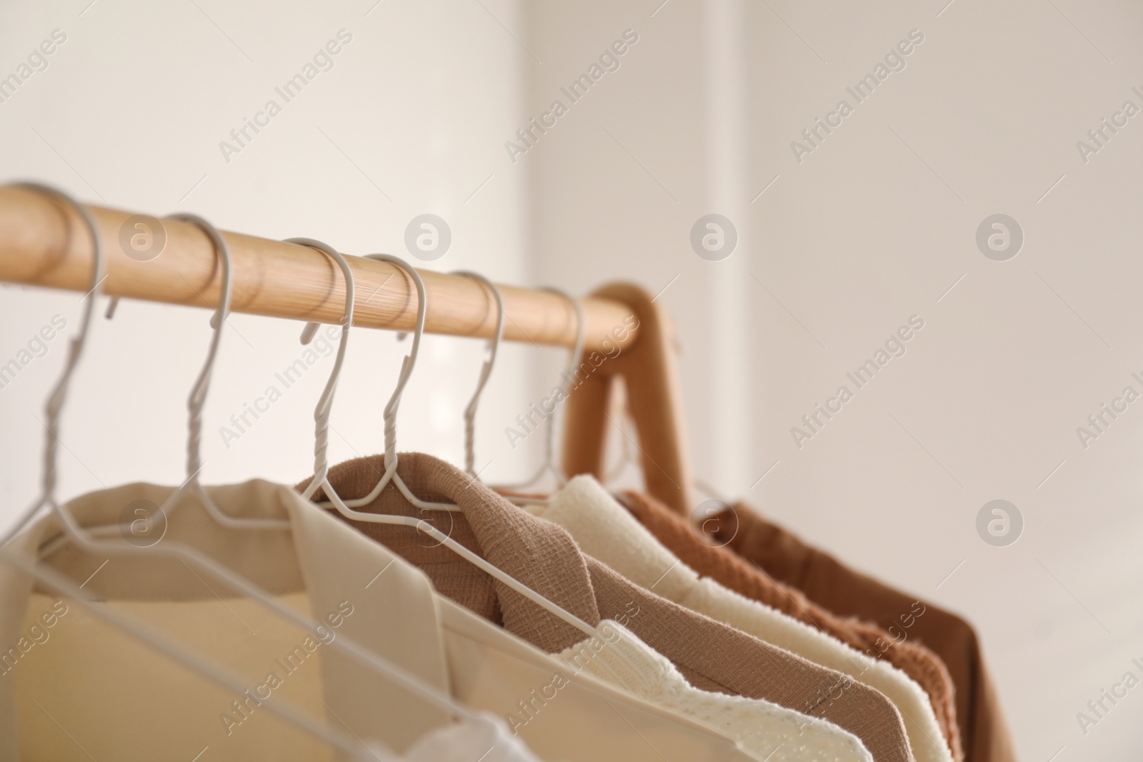 Photo of Rack with stylish women's clothes indoors. Modern interior design