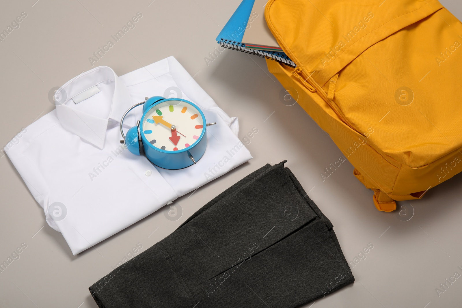 Photo of School uniform for girl and backpack on grey background