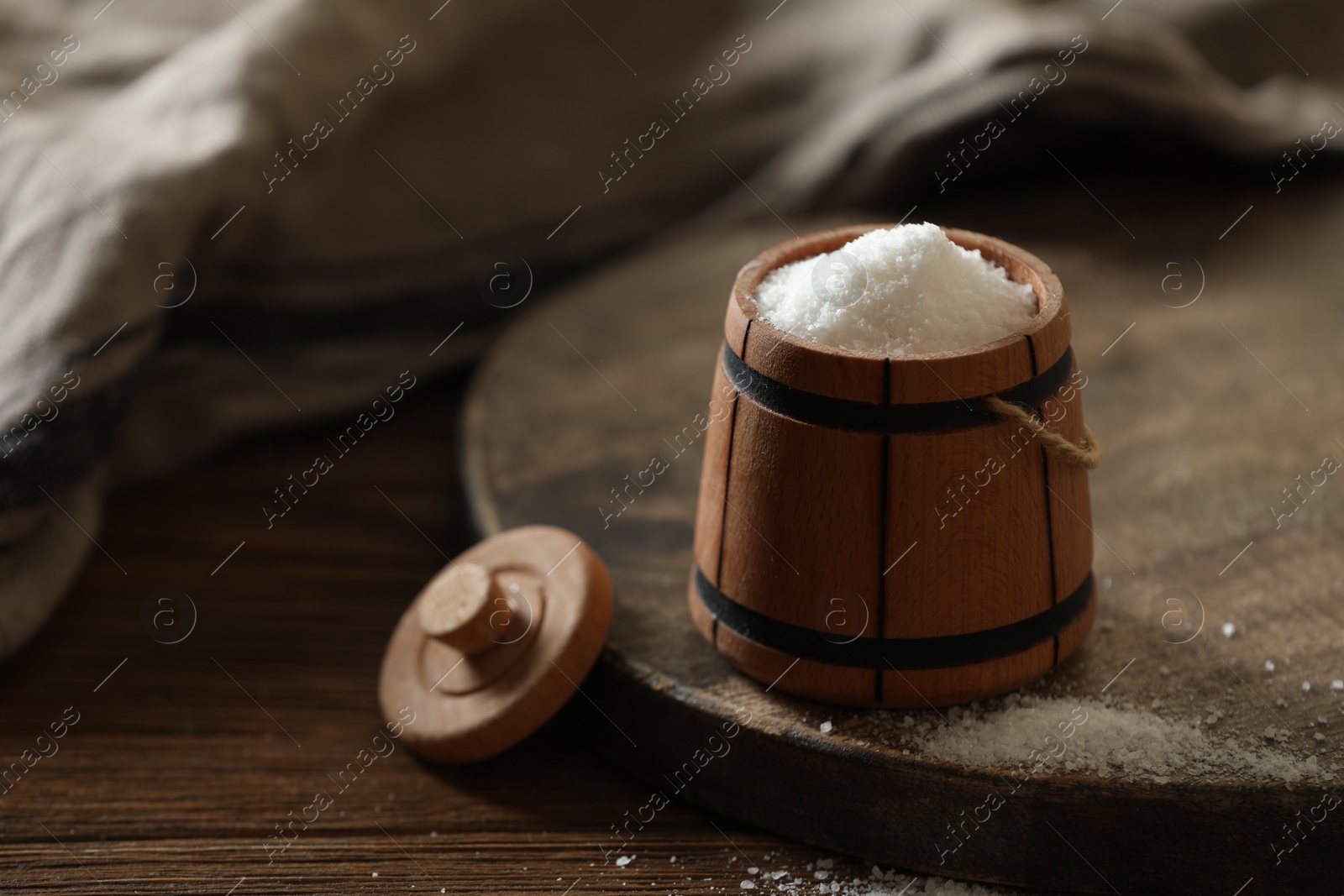 Photo of Organic salt in bowl on wooden table. Space for text