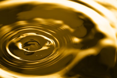 Image of Splash of golden oily liquid as background, closeup