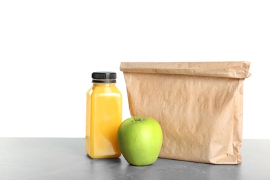 Healthy food and paper bag on table against white background. School lunch