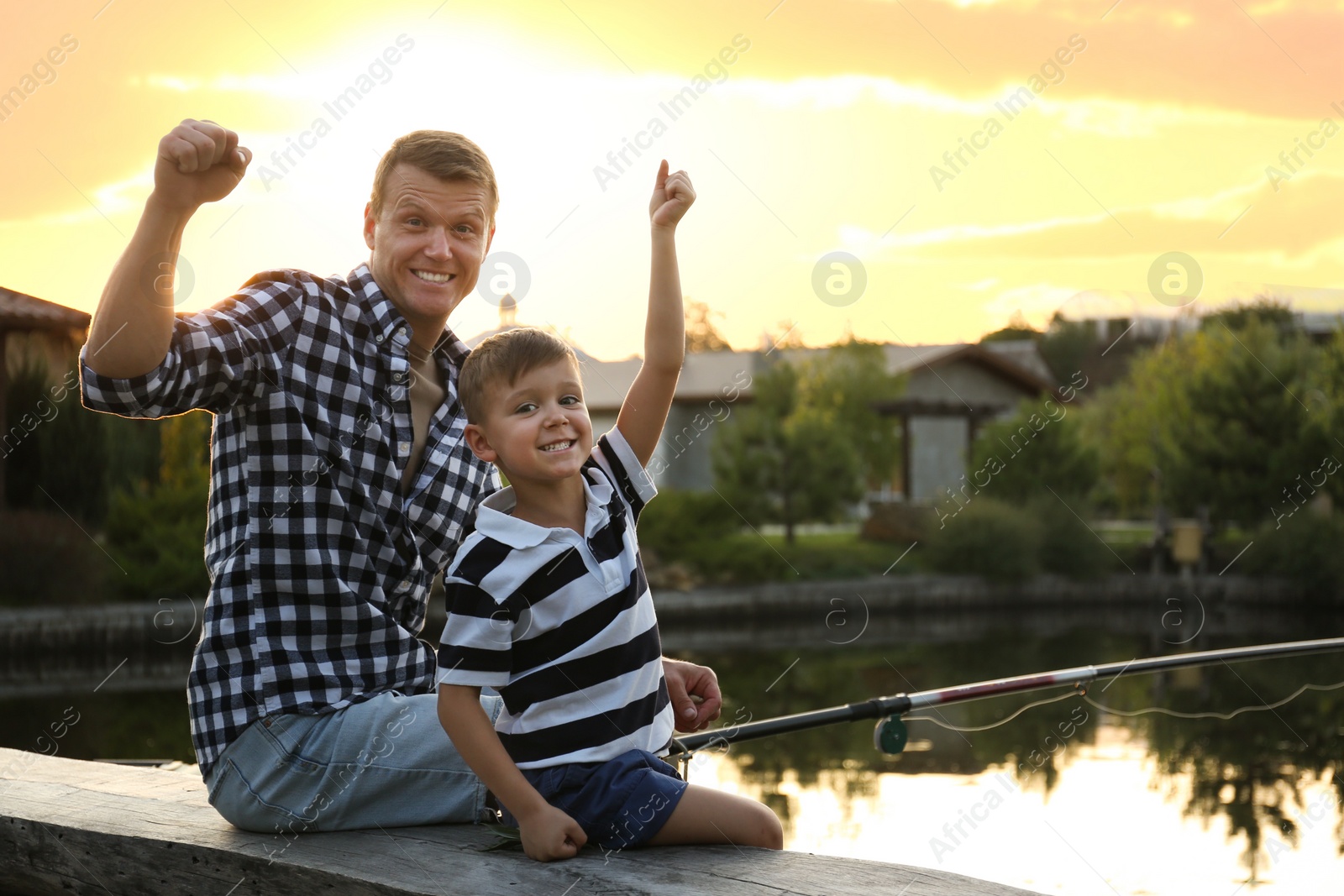 Photo of Dad and son fishing together on sunny day