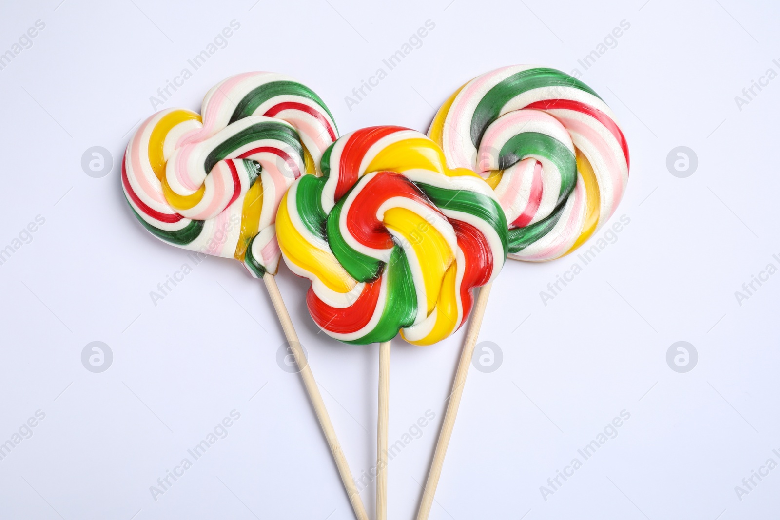 Photo of Sticks with different colorful lollipops on white background, flat lay