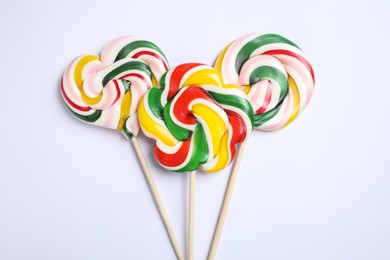 Sticks with different colorful lollipops on white background, flat lay