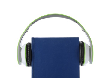 Modern headphones with hardcover book on white background, closeup