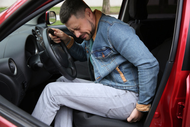 Photo of Man suffering from hemorrhoid pain in car