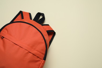 Stylish orange backpack on light background, top view. Space for text