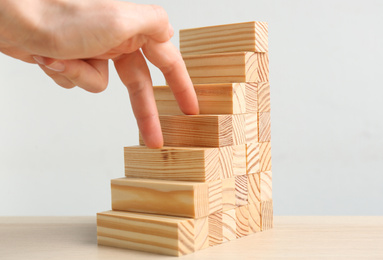 Woman imitating stepping up on wooden stairs with her fingers at table, closeup. Career promotion concept