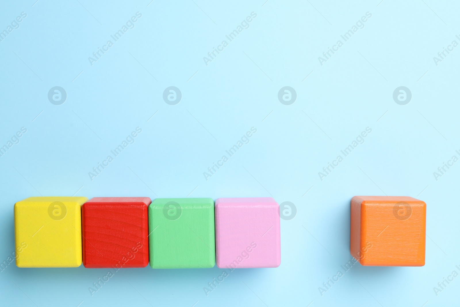 Photo of Flat lay composition with colorful cubes on light blue background, space for text. Pareto principle concept