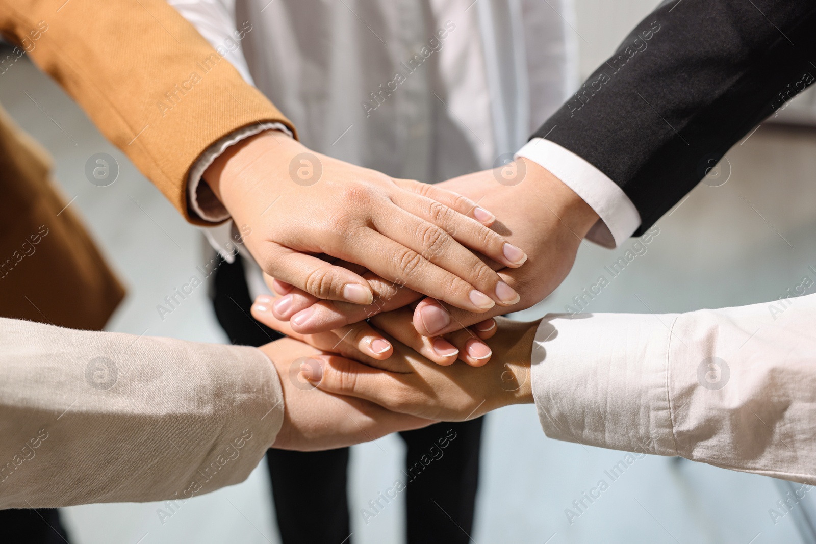 Photo of Group of people holding hands together indoors, closeup. Unity concept