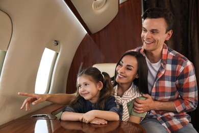 Photo of Happy family looking out window in airplane during flight