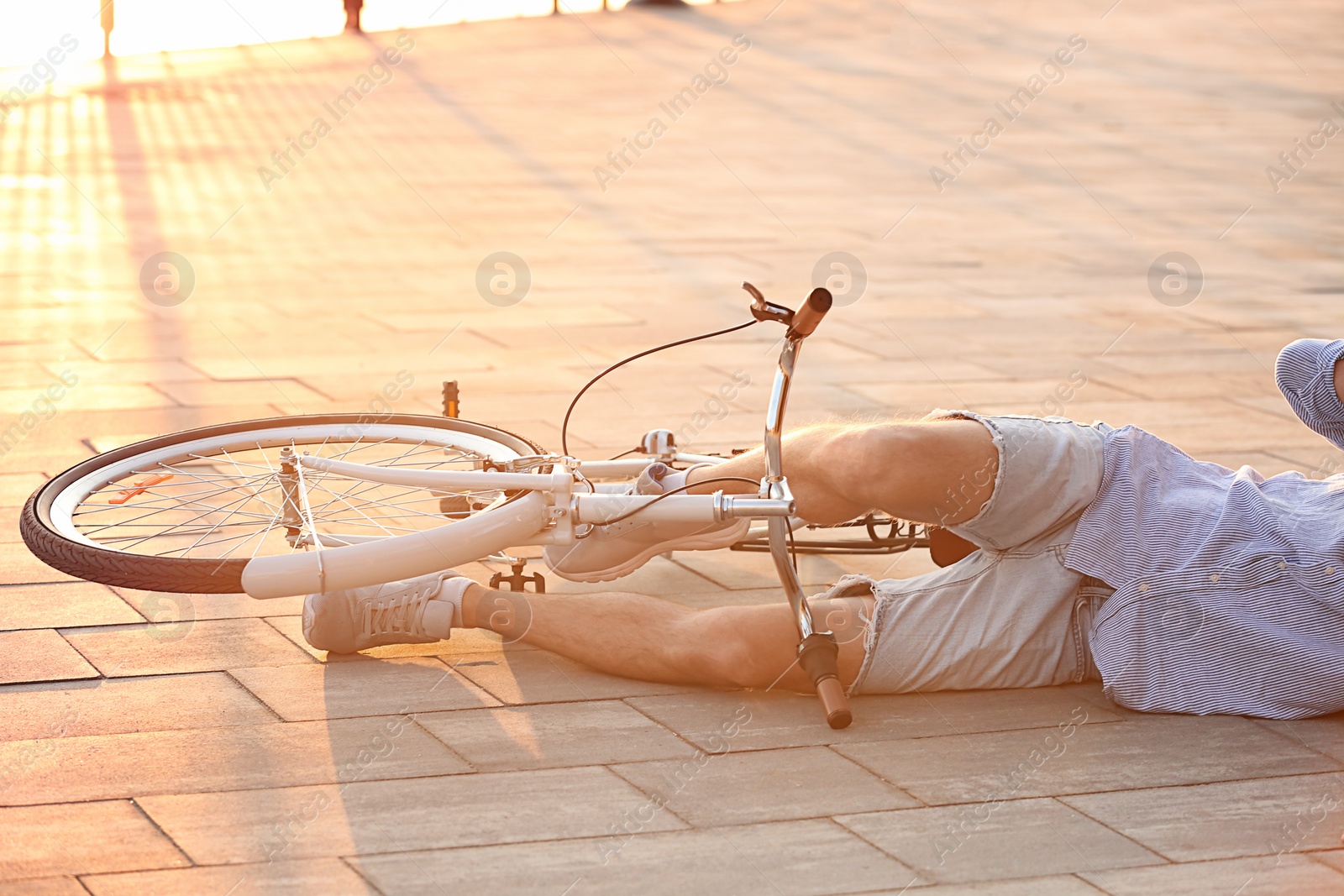 Photo of Man fallen off his bicycle on street, closeup