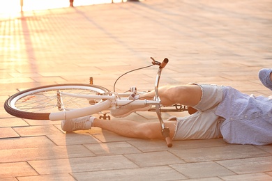 Man fallen off his bicycle on street, closeup