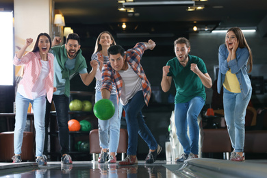 Photo of Man throwing ball and spending time with friends in bowling club