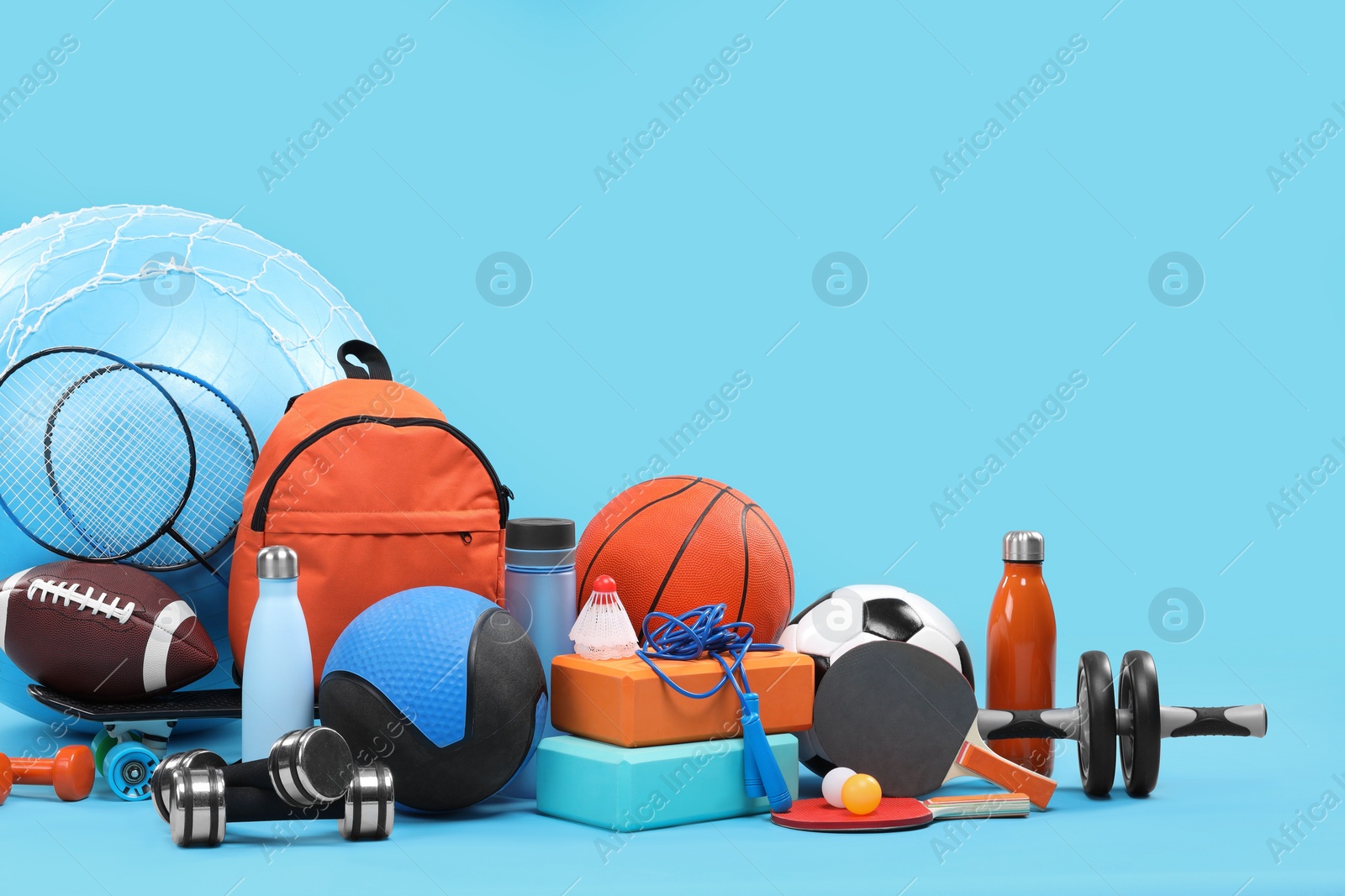 Photo of Many different sports equipment on light blue background, space for text