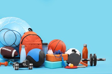 Photo of Many different sports equipment on light blue background, space for text